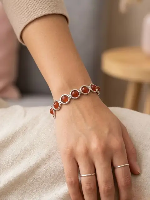 Vintage silver-tone bracelet with round orange cabochon stones and geometric link design.